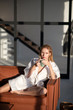 © zinkevych - Beautiful woman in white bathrobe sitting on sofa and resting