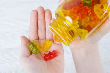 Wall Mural - child holds vitamins for kids like jelly candy