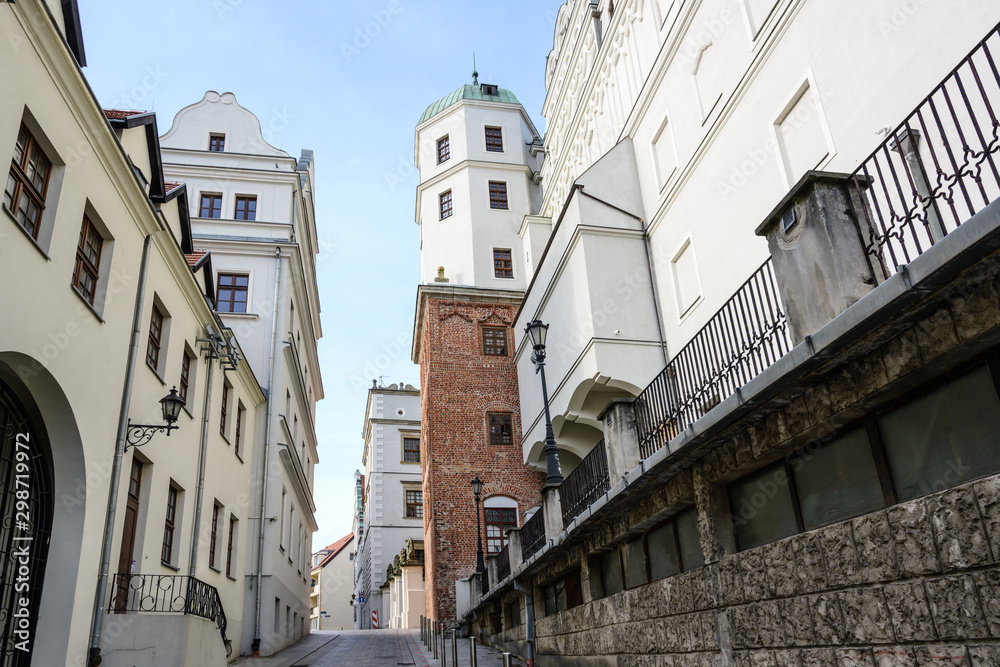 Narrow street between old houses and the Ducal Castle in Szczecin, Poland, former seat of the dukes of Pomerania-Stettin, blue sky - obrazy, fototapety, plakaty 