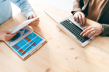 Aufkleber - Financial analysts working with online data and papers by wooden table