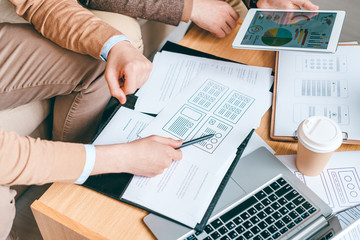 Aufkleber - Young software or program developer with pen pointing at one of papers