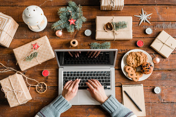 Hands of female over keypad surfing in the net for online shops to order gifts