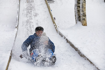 Children in the park in winter. Kids play with snow on the playground. They sculpt snowmen and slide down the hills.