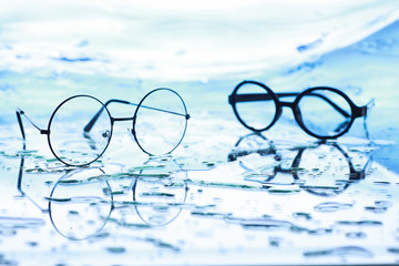 Tools for vision correction. Glasses and lenses with diopters on the background of splashes and blurry.