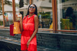 © hetmanstock2 - Black girl in a summer city. Woman with a shoping bags. Lady in a red ress