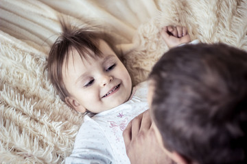 Wall Mural - dad plays with the baby in bed