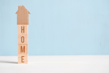 Abstract cardboard house on wooden cubes with the inscription. Concept with place for an inscription.