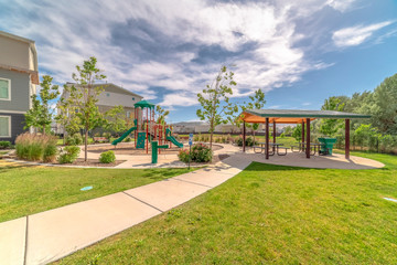 Poster - Park at a sunny neighborhood with childrens playground and pavilion eating area