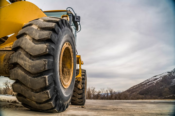 Wall Mural - Focus on the black rubber tires of a yelow bulldozer at a construction site