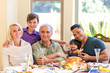 © Deborah Kolb - Multi generation family having a holiday dinner smiling at camera for a family photo