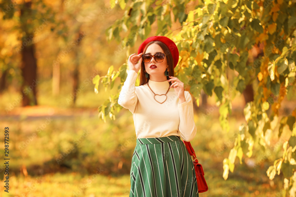 Stylish young woman walking in autumn park