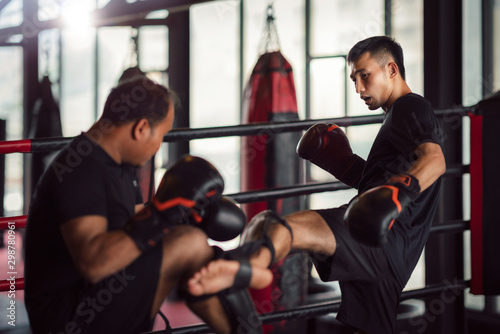 Fotografía Asian kickboxing player and him trainer in boxing gym