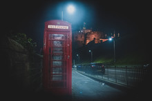 EDINBURGH, SCOTLAND DECEMBER 13, 2018: Old British Red Phone Booth Beside The Road At Night With Castle In The Background.