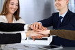 © Iryna - Business people group showing teamwork and joining hands or giving five after signing contract in modern office. Unknown businessman and woman with colleagues or lawyers making circle with their hands