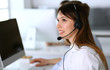 © Iryna - Call center. Group of diverse operators at work. Focus on beautiful asian woman in headset at customer service office. Business concept