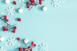 Leinwandbild Motiv Christmas or winter composition. Snowflakes and red berries on blue background. Christmas, winter, new year concept. Flat lay, top view, copy space
