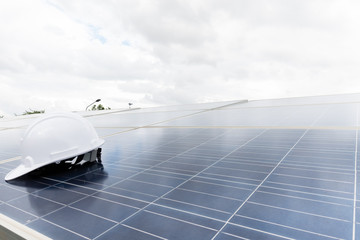 Engineering cap on solar panel with white clouds background,