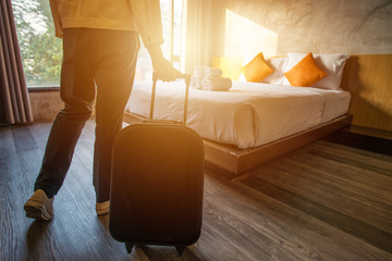 tourist woman pulling her luggage to her hotel bedroom after check-in.
