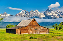 Old Mormon Barn In Grand Teton Mountains With Low Clouds. Grand Teton National Park, Wyoming, USA.