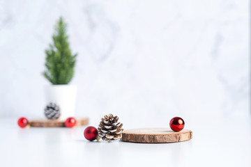 Aufkleber - christmas tree with pine cone and decor xmas ball and empty wood log plate on white table and marble tile wall background.clean minimal simple style.holiday still life mockup to display design