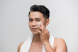 © makistock - smiling man applying cosmetic cream on face,