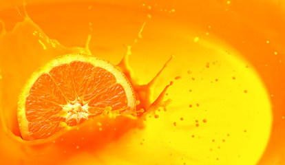 Orange juice splash with orange fruit cut in half.