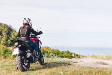 Woman On A Motorbike Looking At The Ocean View. Adventure Trip