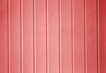 Plastic siding surface in red tone.