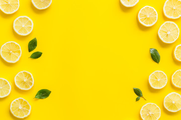 Fruit frame. Lemons and leaves on yellow background top view copy space