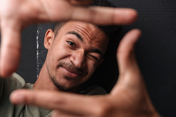 Wall Mural - Image of african american guy looking at camera while taking selfie photo