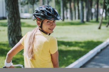 Wall Mural - Beautiful woman in safety helmet riding bicycle outdoors