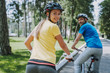 © Yakobchuk Olena - Cheerful woman enjoying bicycle ride with her husband
