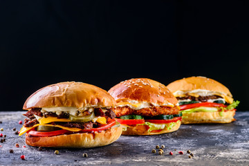 Low angle front view on three delicious chicken, beef and shrimp burgers