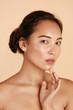 © puhhha - Beauty face. Woman with natural makeup and healthy skin portrait. Beautiful asian girl model touching fresh glowing hydrated facial skin on beige background closeup. Skin care concept