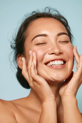 skin care. woman with beauty face touching healthy facial skin portrait. beautiful smiling asian gir
