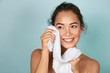 © puhhha - Washing face. Closeup of woman cleaning skin with towel portrait. Beautiful asian girl model wiping facial skin with soft facial towel, removing makeup. High quality studio shot