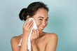© puhhha - Woman cleaning facial skin with towel after washing face portrait. Beautiful happy smiling young asian female model wiping facial skin with soft towel, removing makeup. High quality studio shot