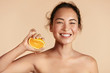 © puhhha - Beauty. Woman with radiant face skin squeezing orange in hand portrait. Beautiful smiling asian girl model with natural makeup, glowing facial skin and citrus fruit. Vitamin C cosmetics concept