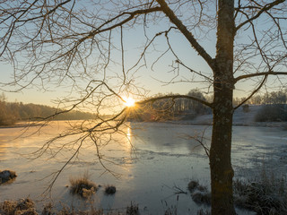 Wall Mural - picture with frozen lake and beautiful trees at sunset