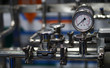 View of analog meter ,steel pipes and industrial process equipment background           