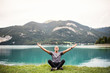 © Halfpoint - A senior man pensioner sitting by lake in nature, doing yoga exercise.