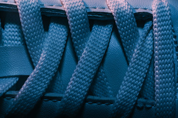 Close up beautiful white shoeloces with color light background texture. Macro photography view.