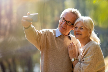 Poster - Senior couple taking selfie with smartphone in park