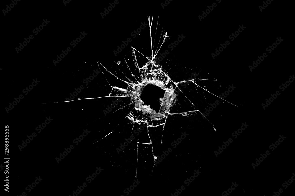 hole in the glass with cracks isolated on a black background - obrazy, fototapety, plakaty 