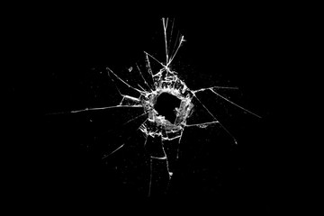 Poster - hole in the glass with cracks isolated on a black background