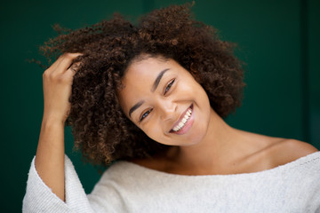 Wall Mural - close up beautiful young african american woman smiling with hand in hair