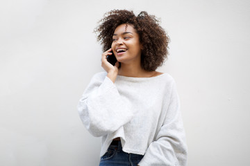 happy african american woman talking with mobile phone by white background