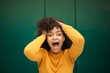 © mimagephotos - Close up surprised young african american woman with hands in hair and mouth open