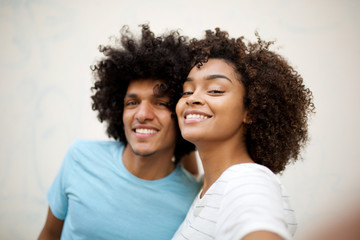 Wall Mural - close up happy african american couple taking selfie by white wall