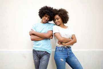 Wall Mural - cool young african american couple standing against white background with arms crossed